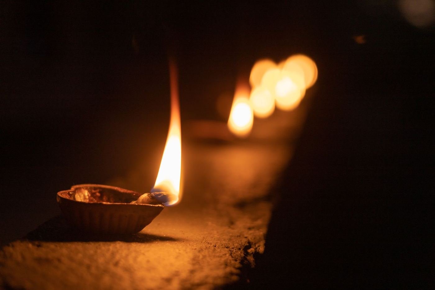 A traditional diya oil lamp glowing warmly at night