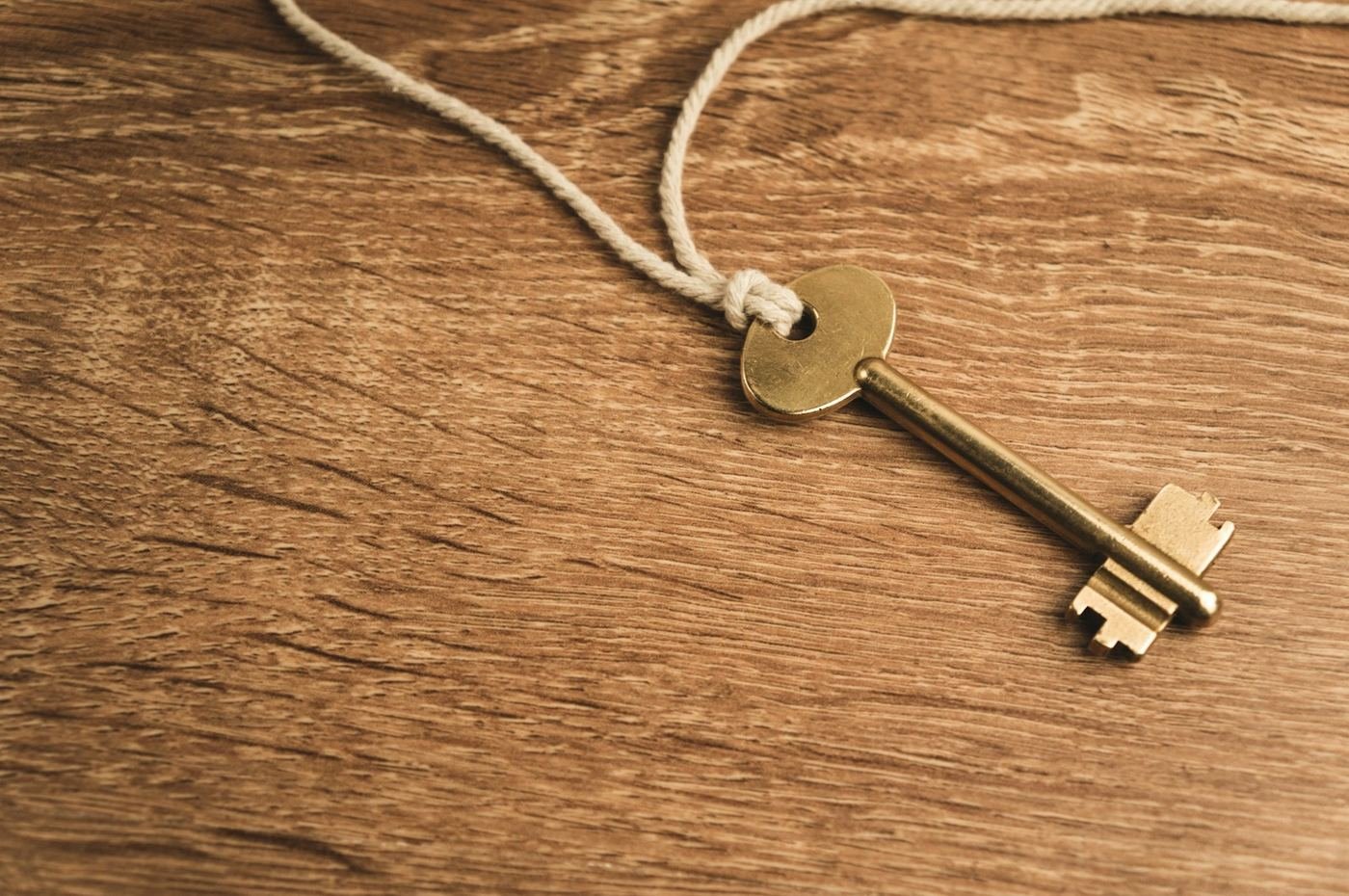 An old brass key resting on a stack of forgotten bank passbooks and documents
